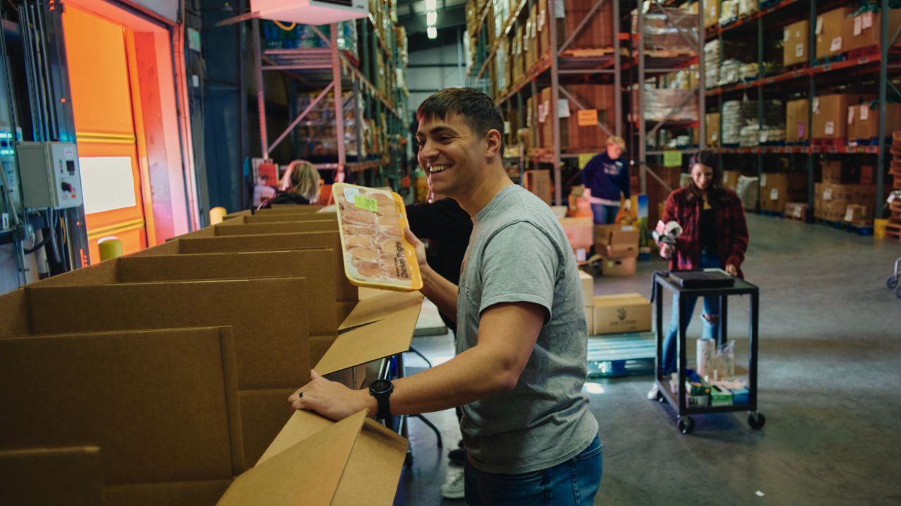 A man places food into a donation box
